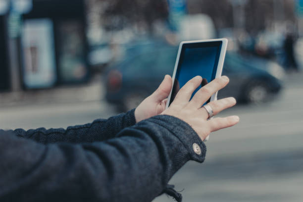 istock Hands with digital tablet on blurred city background 641310420