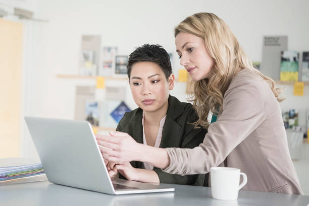 istock Two female office workers looking at laptop, one pointing to screen 641311064