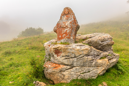 Three stones stacked on a bed of algae overlooking the rocky bay.