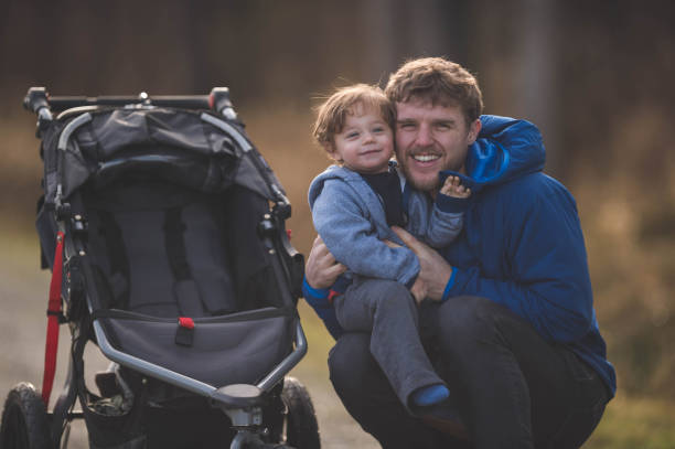 istock Young dad pushing baby stroller outside 641315090