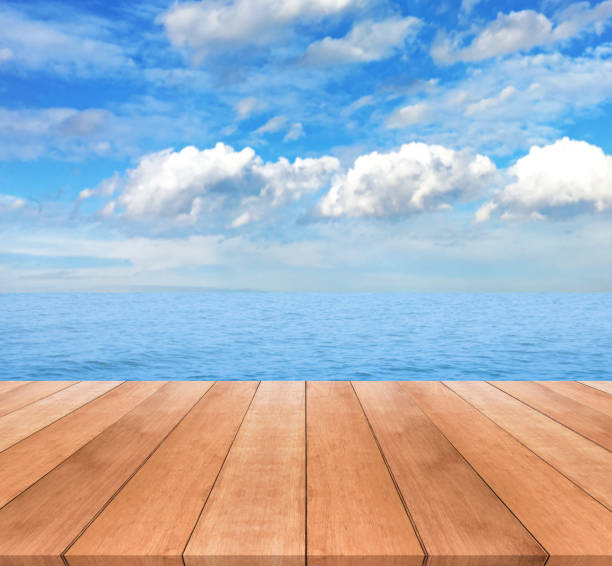 istock Wood table top on blue sea and sky background 641317324