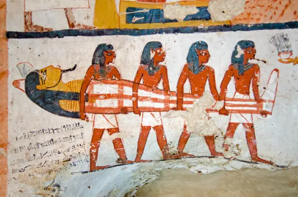 Four men carrying a mummy.  Detail of the decoration of the tomb of Amenemonet, a priest in the Ramesside Period of Ancient Egypt.  West Bank, Luxor.