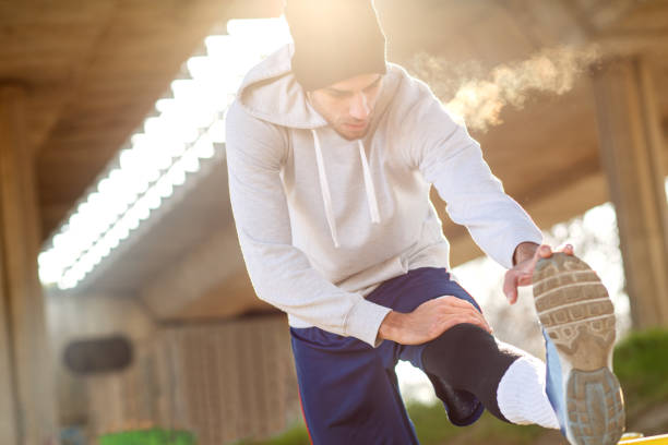 istock Young man stretching his muscles under the bridge. 641328038