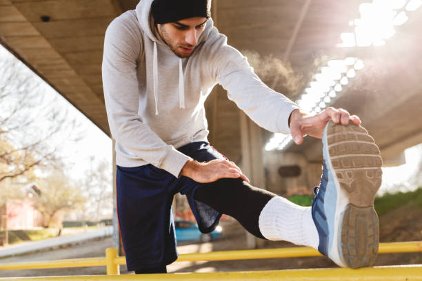 istock Young man stretching his muscles under the bridge. 641328598