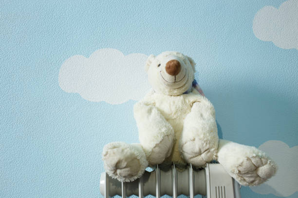 Frozen toy white polar bear sit on the heater Frozen toy white polar bear sit on the heater environmental pressure oven photos stock pictures, royalty-free photos & images