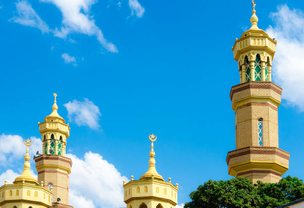 Four minaret towers under blue cloudy sky Four yellow minaret towers under blue sky with a few clouds in the capitol city Lilongwe, Malawi. malawi stock pictures, royalty-free photos & images