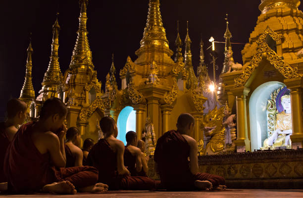 Young Buddhists praying in Shwedagon Pagoda, Myanmar stock photo