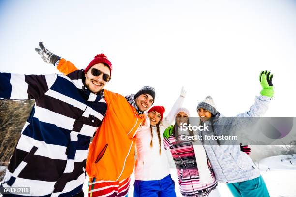 Young Friends In Skiwear With Arms Raised Stock Photo - Download Image Now - 20-29 Years, Adult, Adults Only