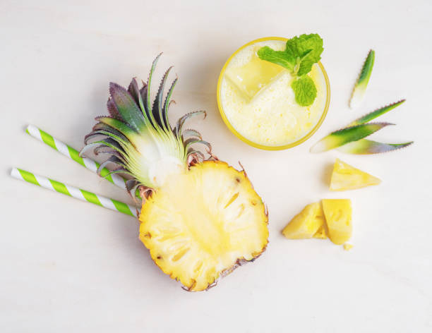 Cool healthy drink with pineapple on white wood stock photo