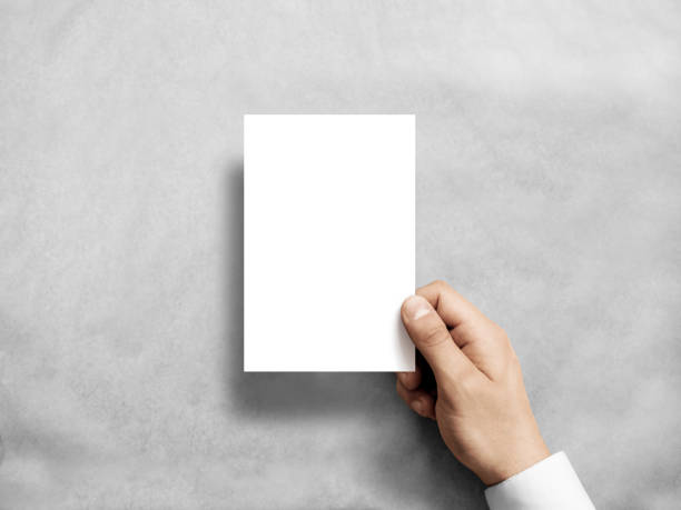 istock Hand holding blank white vertical postcard flyer mockup 641349456
