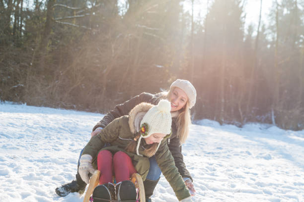 istock Mother and daughter haveing fun on sleds 641355064