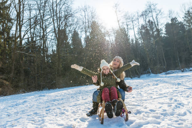 istock Mother and daughter haveing fun on sleds 641355070