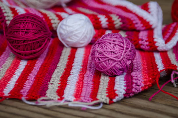 istock small yarn balls on crocheted striped fabric in red colors 641358382