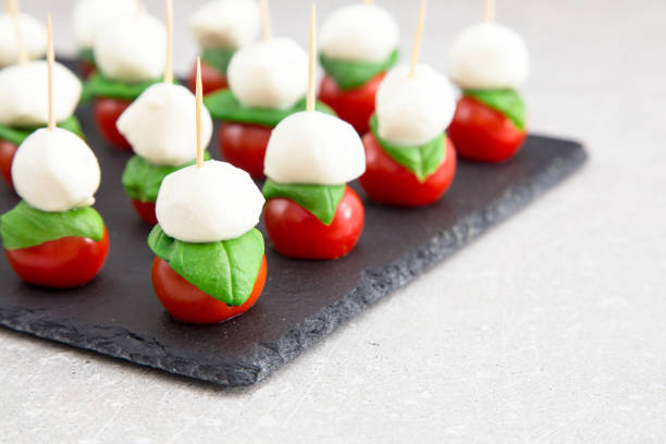 Caprese salad. Skewers with tomato and mozzarella with basil. Caprese salad. Skewers with tomato and mozzarella with basil caprese salad stock pictures, royalty-free photos & images