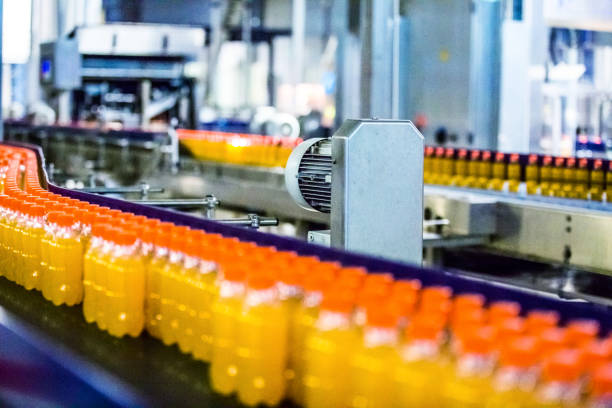 Bottles on Conveyor Belt in Factory Bottles on Conveyor Belt in Factory industrial orange stock pictures, royalty-free photos & images