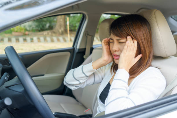 istock Young woman touching her temple feels headache in car 641364480