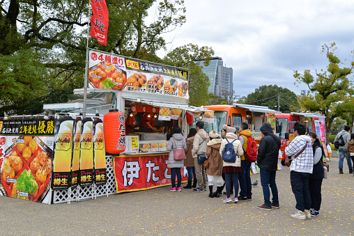 Osaka, Japan - November 23, 2016: Many people are queuing to buy Takoyaki at food truck near Osaka castle, Osaka, Japan