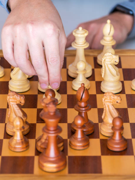 istock Middle game - the hand with pawn makes a move on chess Board 641367210