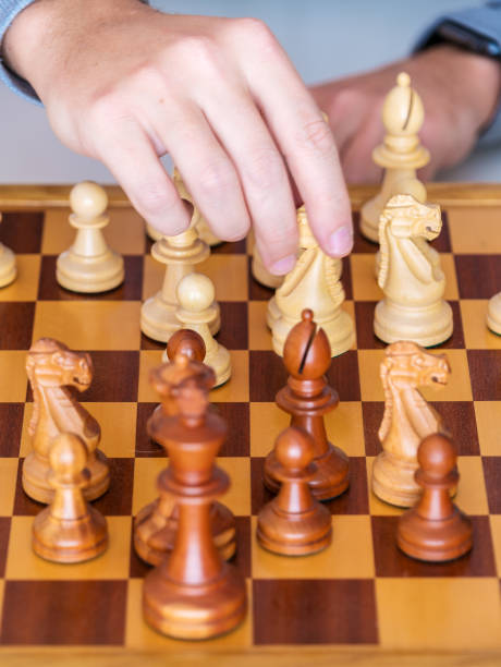 istock Middle game - the hand with knight makes a move on chess Board 641367258