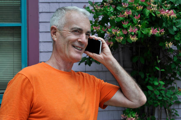 Handsome Senior Man Talking on Cell Phone in Colorful Setting stock photo