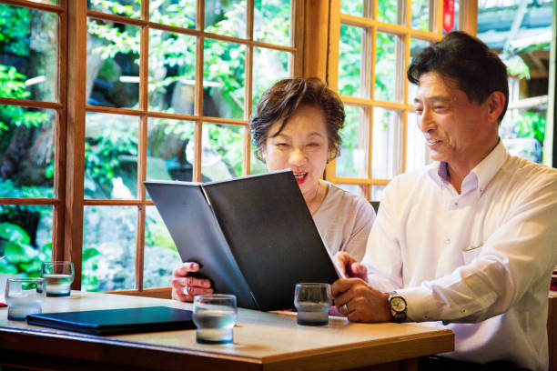 istock Elderly Japanese couple choosing their meal at cafe 641385366