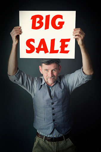 handsome stylish man holding a sign with the words Big Sale