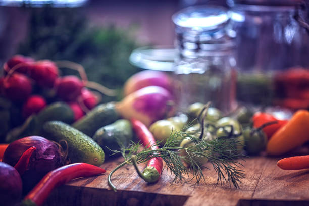 Preserving organic vegetables in jars like carrots, cucumbers, tomatoes, chili's, paprika and radishes.
