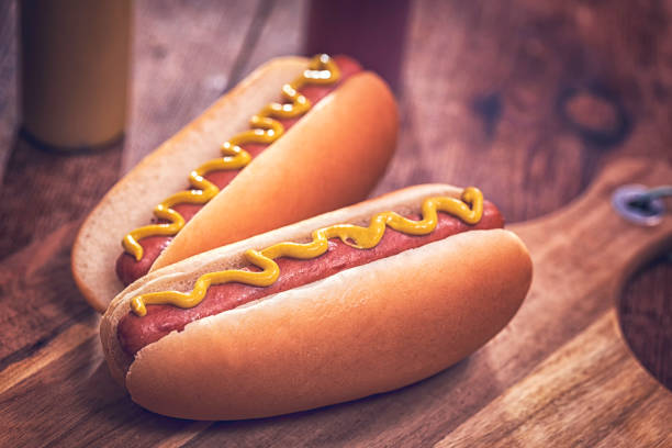 Hot Dogs with Mustard Preparing homemade hot dogs with mustard hot dog stock pictures, royalty-free photos & images