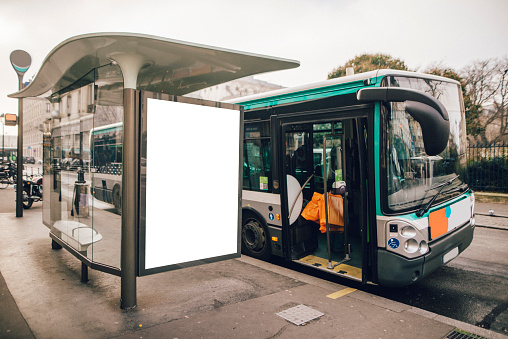 A bus stop with a billboard in Paris, France.