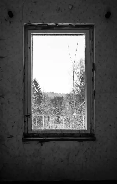 old window in an abandoned room in black and white
