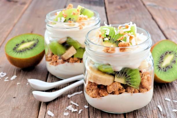 키 위, 바나나, 코코넛 디저트 소박한 나무에 메이슨 항아리에 - greek yogurt 뉴스 사진 이미지