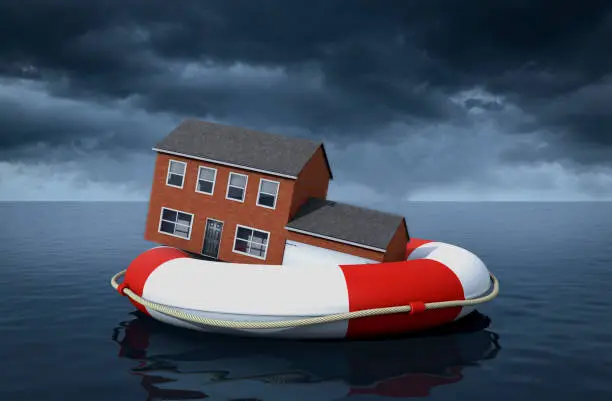 Flood Insurance  Concept - A house floating on a life ring in large body of water in a storm.