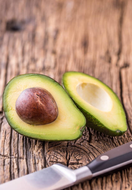 istock Avocado. Cut avocado on a oak wood background table. 641409068