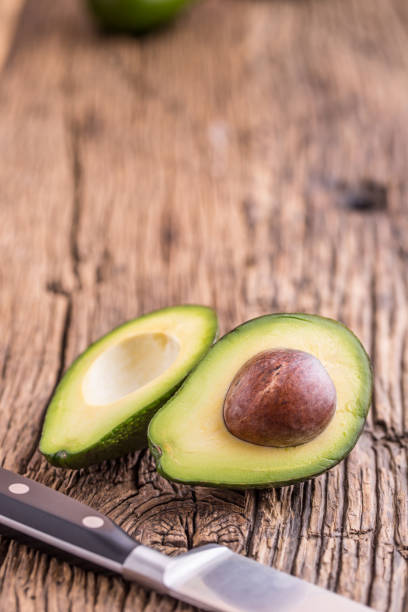 istock Avocado. Cut avocado on a oak wood background table. 641409094