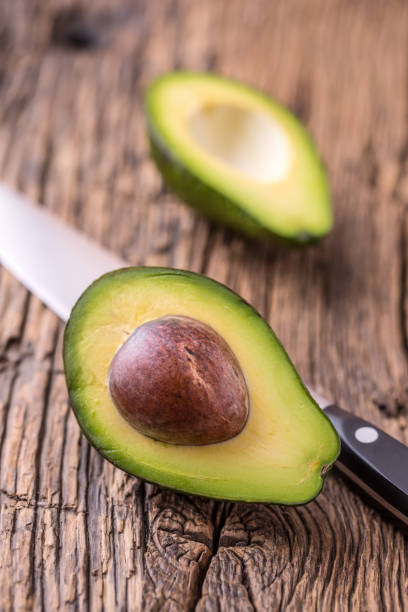 istock Avocado. Cut avocado on a oak wood background table. 641409112