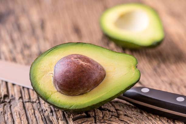 istock Avocado. Cut avocado on a oak wood background table. 641409160