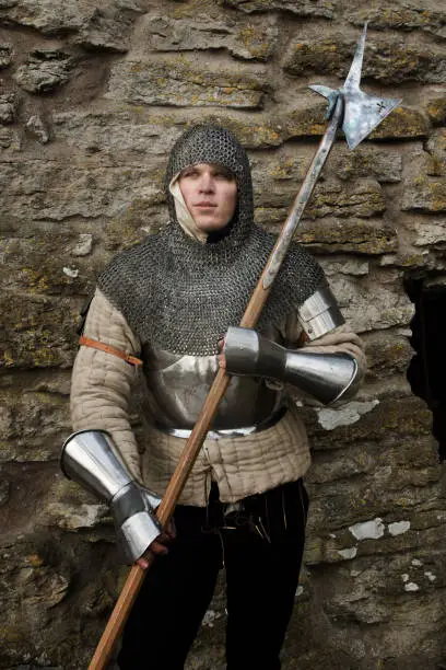 Photo of Swedish man wearing medieval chain mail armor holds a weapon