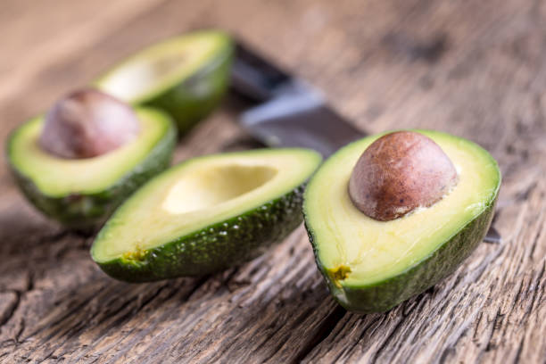 istock Avocado. Cut avocado on a oak wood background table. 641411460