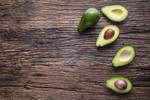 istock Avocado. Cut avocado on a oak wood background table. 641411674