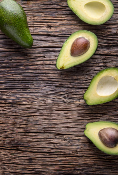 istock Avocado. Cut avocado on a oak wood background table. 641411744