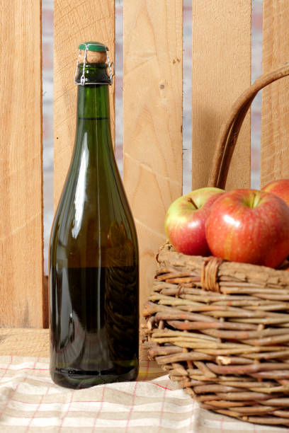 Basket with green apples stands on a table on the background of an old board and burlap
