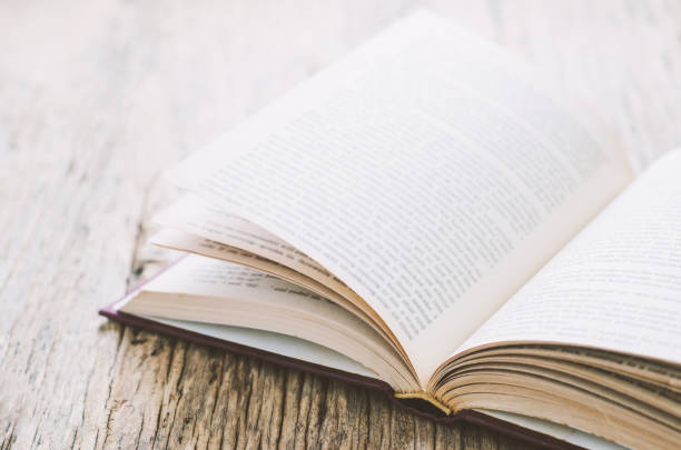 istock Old book opened on dirty wooden background 641420600