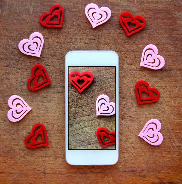 istock smartphone with hearts on wooden background. Valentine's day concept. 641421234