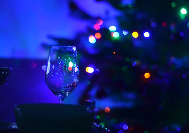 one empty wine glass and abstact night blury defocus bokeh light background photography