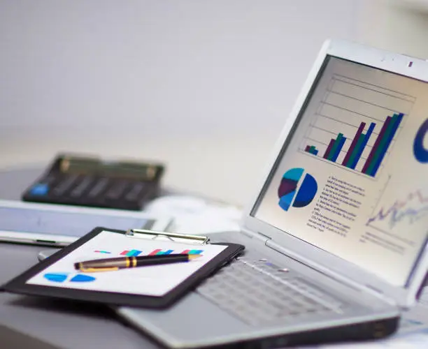 Photo of Businessman analyzing investment charts with a laptop. Accounting, increasing graph on the screen