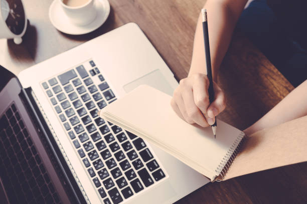 Female writing information on paper in workplace. office concept.