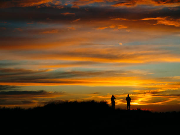 istock Silhouette of people looking the sunset beach 641426130