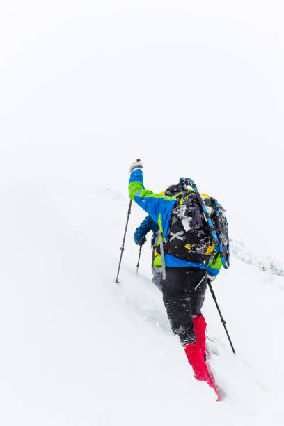 istock Men hiking on mountain during snow storm 641427182