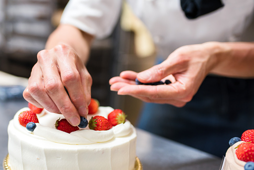 istock Baker adding blueberries to a cake 641428548