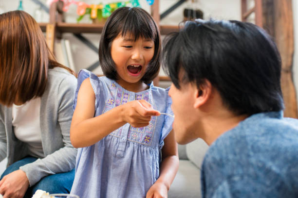 istock Girl feed birthday cake to her father 641429238